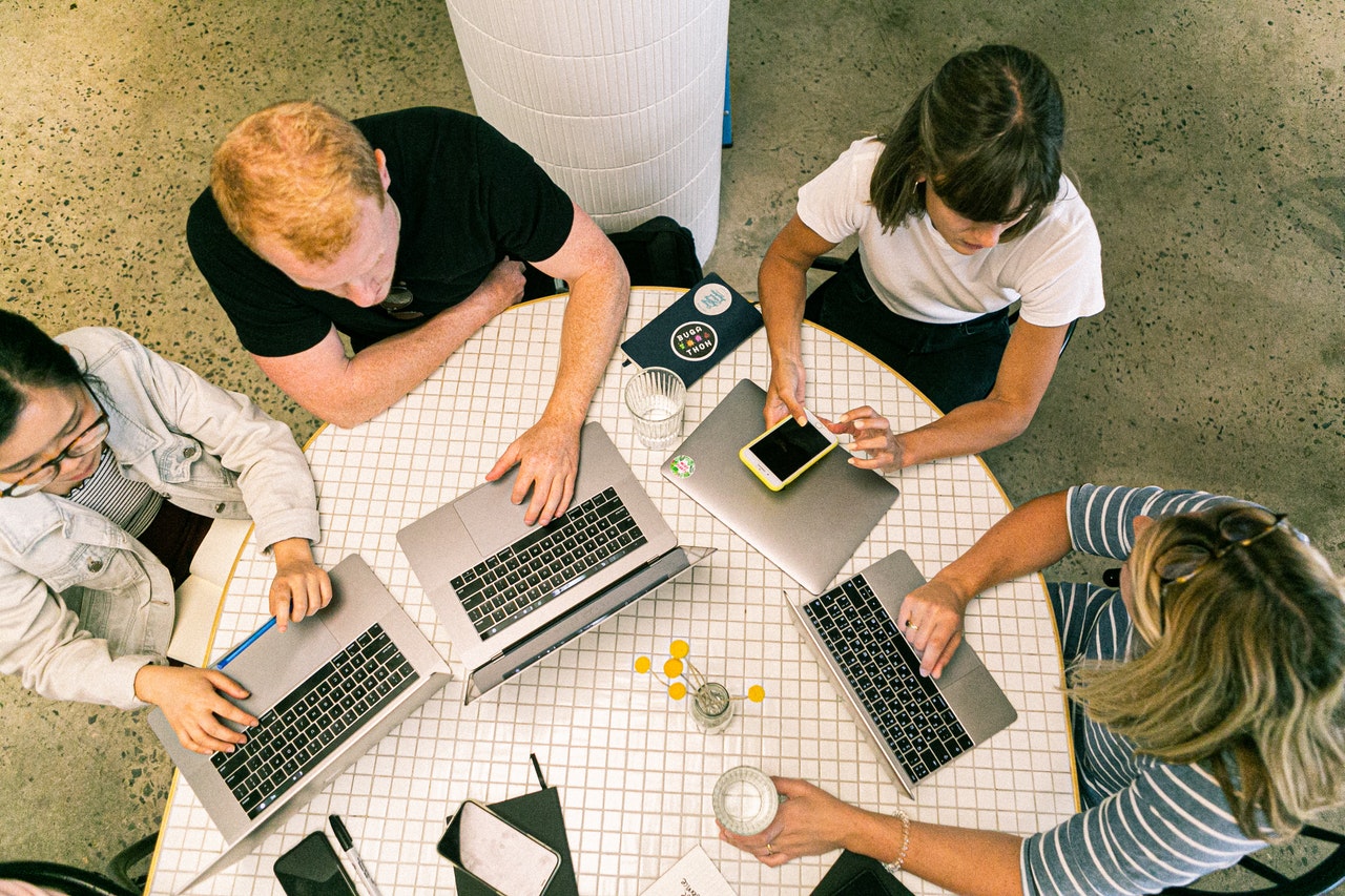 People sat around a table showing collaboration is key in marketing efficiency