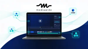 Enterprise marketer’s desk with a laptop displaying a generic personalized video interface, surrounded by abstract data lines and nodes that represent automated, data-driven video personalization at scale.